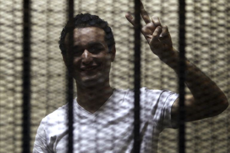 Egyptian activist Ahmed Douma gestures from behind bars during his trial at the New Cairo court, on the outskirts of Cairo June 3, 2013. A court sentenced Douma to six months in prison on Sunday, with the option of paying a bail of 5,000 Egyptian pounds ($716) to be released. Douma was accused of insulting President Mohamed Mursi and spreading false information with the purpose of disrupting public order. REUTERS/Amr Abdallah Dalsh (EGYPT - Tags: POLITICS CIVIL UNREST C