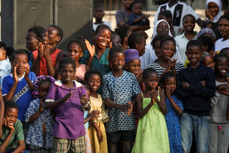 Children react as they watch local dancers perform during an annual slum party in Oworonshoki, Lagos