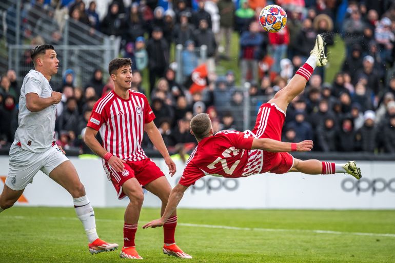 Olympiacos' Greek midfielder Theofanis Bakoulas #23 shoots to score his team's third goal during their UEFA Youth League final fooball match between Olympiacos and AC Milan at Colovray Sport Center in Nyon, on April 22, 2024. (Photo by Fabrice COFFRINI / AFP)