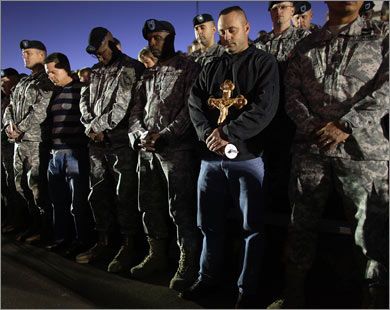 U.S. Army soldiers bow their heads in prayer during a vigil for those killed and wounded when U.S. Army Major Nidal Malik Hasan went