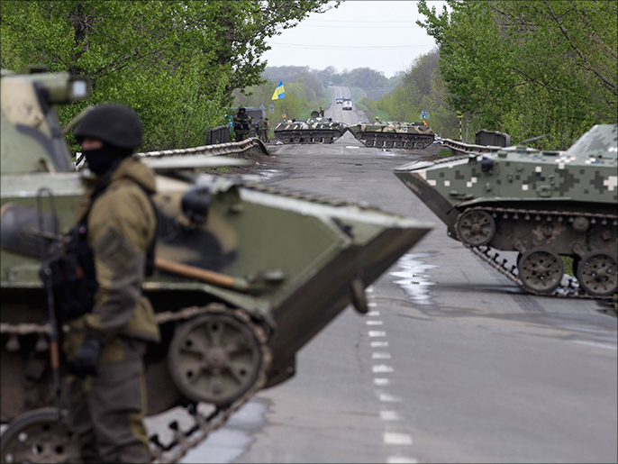 A Ukrainian soldier stands guard in front of armoured personnel carriers at a check point near the village of Malinivka, southeast of Slaviansk, in eastern Ukraine April 29, 2014. REUTERS/Baz Ratner (UKRAINE - Tags: POLITICS CIVIL UNREST)