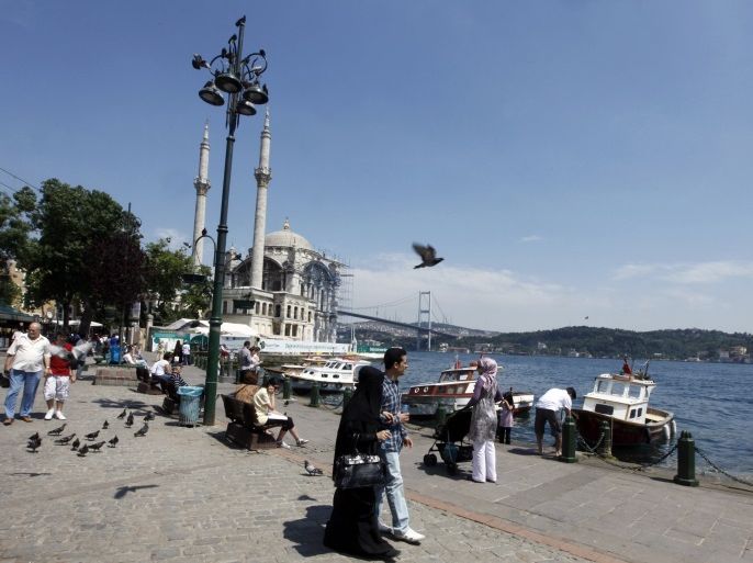 Tourists walk in front of the Ottoman era Ortakoy Mecidiye Mosque and Bosphorus Bridge in Istanbul July 5, 2011. Muslim but non-Arab Turkey has become a hot destination for Arab tourists and investors in recent years as Turkey has emerged as a regional power in the Middle East under Prime Minister Tayyip Erdogan's AK Party. Picture taken July 5, 2011. To match feature TURKEY-TOURISM/ REUTERS/Osman Orsal (TURKEY - Tags: TRAVEL POLITICS BUSINESS)