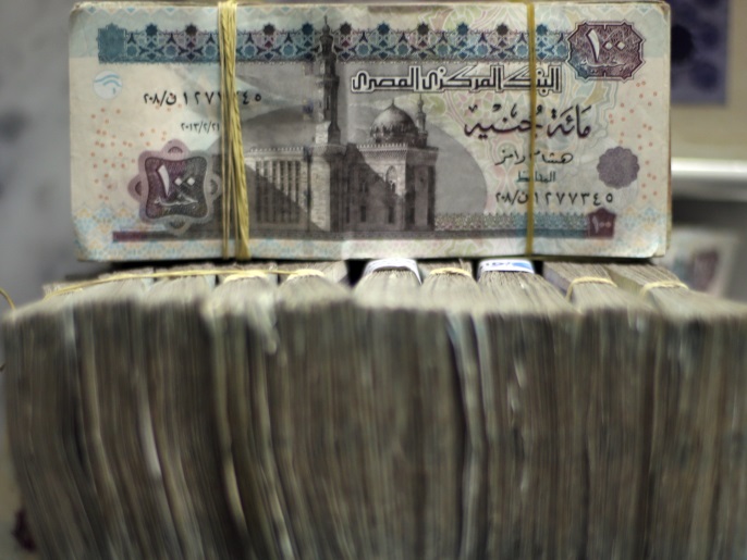 Des billets de livre égyptienne sont fichés par paquets de 100 alors que les employés comptent de l'argent dans un bureau de change au centre-ville du Caire, le 5 juin 2014. Le marché noir égyptien des devises est menacé de deux côtés, alors que l'aide des riches États du Golfe promet de soulager la pénurie de dollars et qu'une Banque centrale de plus en plus confiante orchestre une dépréciation graduelle de la livre égyptienne. REUTERS/Amr Abdallah Dalsh (EGYPTE - Tags: POLITIQUE AFFAIRES)