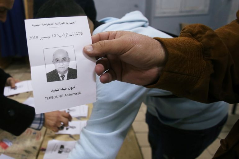 An election official holds a ballot paper of Algeria's presidential candidate Abdelmadjid Tebboune during the vote counting process at a polling station in Algiers, Algeria December 12, 2019. REUTERS/Ramzi Boudina