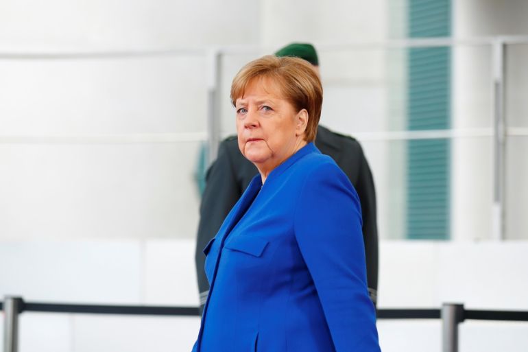 German Chancellor Angela Merkel waits to welcome Republic of the Congo's President Denis Sassou Nguesso at the beginning of the Libya summit in Berlin, Germany, January 19, 2020. REUTERS/Hannibal Hanschke