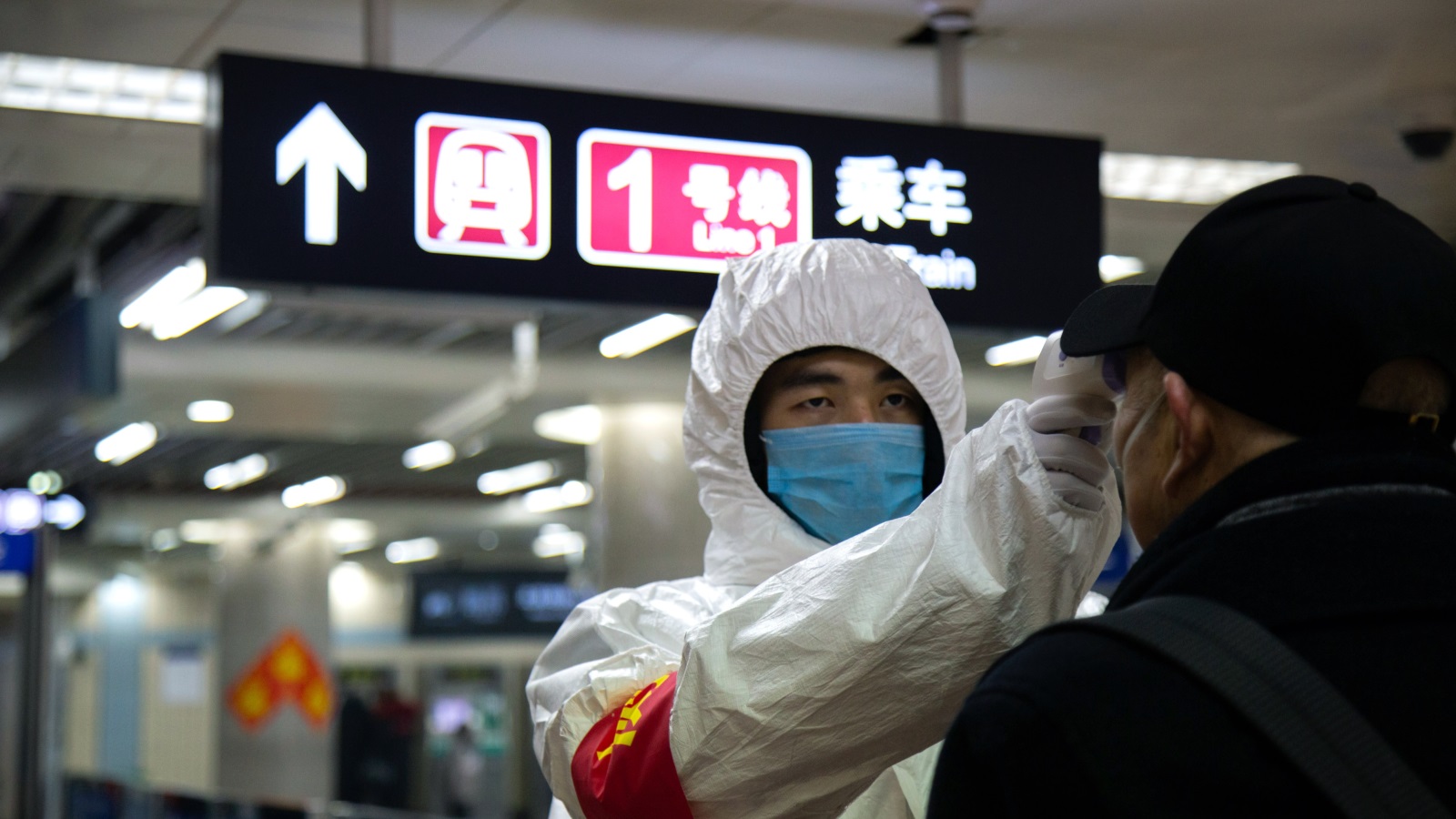 ‪أحد موظفي قطاع الصحة في الصين يفحص حرارة رجل تحسبا لإصابته بفيروس كورونا داخل محطة للمترو في بكين‬ (غيتي)
