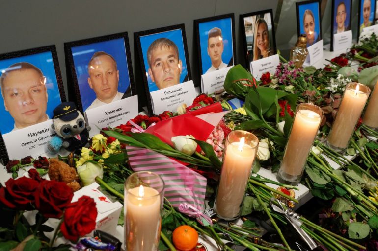 Flowers and candles are placed in front of the portraits of the flight crew members of the Ukraine International Airlines Boeing 737-800 plane that crashed in Iran, at a memorial at the Boryspil International airport outside Kiev, Ukraine January 11, 2020. REUTERS/Valentyn Ogirenko