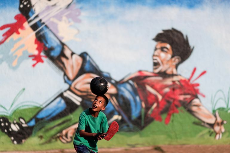A child plays soccer in a street at the neighborhood of Ceilandia in Brasilia