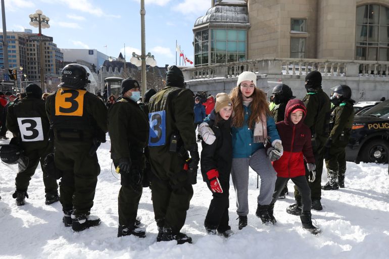 Kids walk to their hotel to get medicine for their father who is a trucker in a wheelchair, as truckers and supporters continue to protest coronavirus disease (COVID-19) vaccine mandates, in Ottawa, Ontario, Canada, February 18, 2022. REUTERS/Carlos Osorio