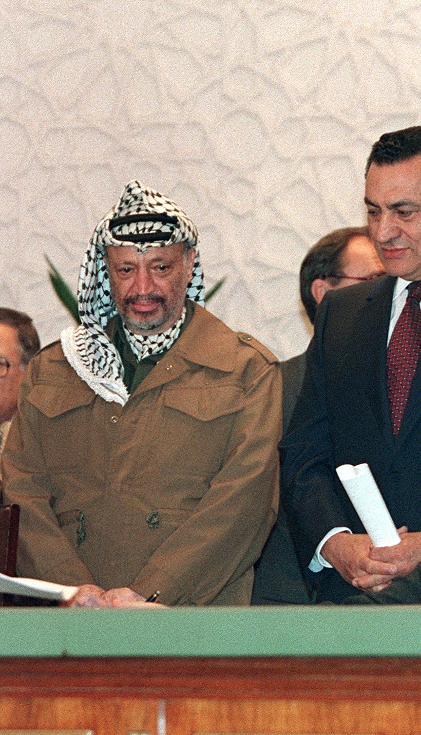 Palestinian negotiator Ahmed Qorei Abu Ala (L) from داخلية فقط** Palestine Liberation Organization (PLO) and Israeli diplomat Uri Savir (R), both principal architects of the Oslo peace accords, sign 09 February 1994 in Cairo agreements reached on Palestinian self-rule in Gaza and Jericho, while PLO chairman Yasser Arafat (C), Egyptian President Hosni Mubarak (2nd-R) and Israeli Foreign Minister Shimon Peres (R) look on. The Palestinians are ready to accept "a unified international Jerusalem" if that is what it takes to reach peace with Israel, Abu Ala, the Palestinian legislature speaker said in an address to the European Parliament in Strasbourg 05 September 2000. (Photo by MANOOCHER DEGHATI / AFP)