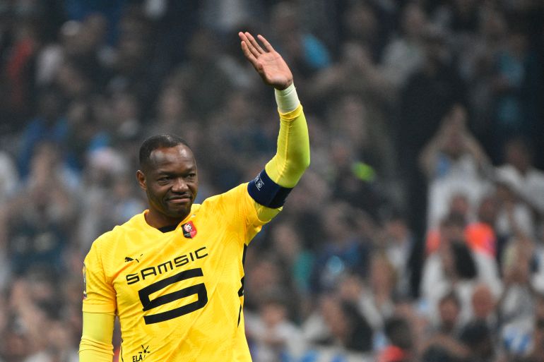 (FILES) Rennes' French goalkeeper #30 Steve Mandanda salutes the OM supporters after receiving the captain's armband at the end of their ligue 1 football match Olympic of Marseille (OM) against stade Rennais at the Velodrome stadium, in Marseille on May 17, 2025. International goalkeeper Steve Mandanda, world champion with the French team in 2018, announced at the age of 40 that he was calling time on his career in an interview with the newspaper L'Equipe on September 10, 2025. (Photo by Christophe SIMON / AFP)