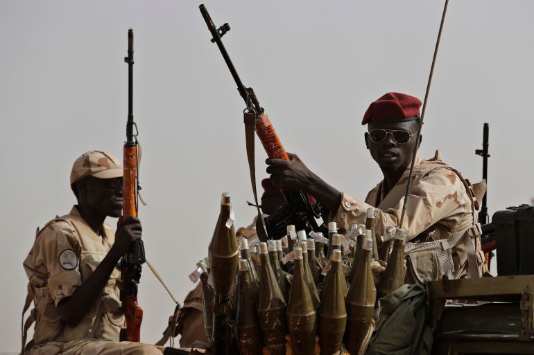 FILE - Sudanese soldiers from the Rapid Support Forces unit, led by Gen. Mohammed Hamdan Dagalo, the deputy head of the military council, secure the area where Dagalo attends a military-backed tribe's rally, in the East Nile province, Sudan, June 22, 2019. (AP Photo/Hussein Malla, File)