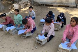 11- تحت ظل شجرة وعلى أرض قاسية يجلس أطفال لتلقي تعليمهم بعدما دمر الاحتلال مدرستهم "العروبة" في مخيم النصيرات للاجئين وسط قطاع غزة / رائد موسى / النصيرات / الجزيرة نت