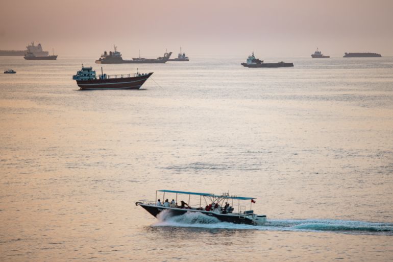 MUSCAT, OMAN - JUNE 19: A tourist boat passes near crude oil tankers, bulk carriers, and other vessels anchored off Qaboos Port in Muscat, Oman, on June 19, 2026. The port as a hub for regional trade has become a crucial maritime traffic point. The Strait of Hormuz, a vital shipping route for the region's oil and gas, was effectively blockaded since the outbreak of war between the United States and Iran in late February. This week's provisional peace deal between the countries was meant to reopen the waterway to shipping traffic, but the pace of that reopening is unclear amid continued fighting in Lebanon and the need to clear the Strait of sea mines. (Photo by Elke Scholiers/Getty Images)