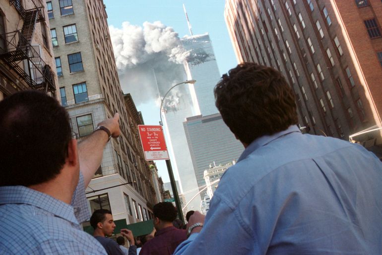Pedestrians react to the World Trade Center collapse September 11, 2001. Two commercial airplanes crashed into the World Trade Center earlier. REUTERS/Richard Cohen AC