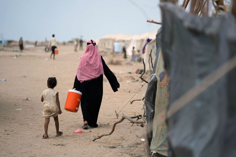 Women carry drinking water back to their tents at Al-Firdous camp. Water is supplied to parts of the camp through tanks and a well dug by the local authorities المصدر WHO Yemen