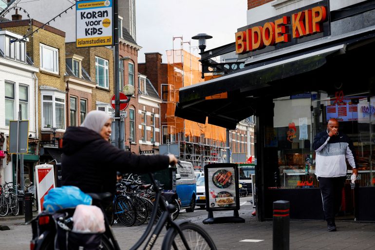 People walk past shops in Kanaalstraat, an immigrant-dominated area in the neighborhood of Lombok of the central Dutch city of Utrecht, Netherlands November 23, 2023. REUTERS/Piroschka van de Wouw REFILE - CORRECTING LOCATION FROM "KANALENEILAND" TO "KANAALSTRAAT".
